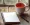 Serene setting with a table holding a steaming cup of tea and a blank notebook for a quiet study or reflection moment.