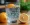 Clear glass filled with water and a vibrant orange slice, against a clean, neutral background.