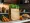 Fresh vegetables including carrots, tomatoes, bell peppers, and leafy greens in a paper bag on a clean countertop.